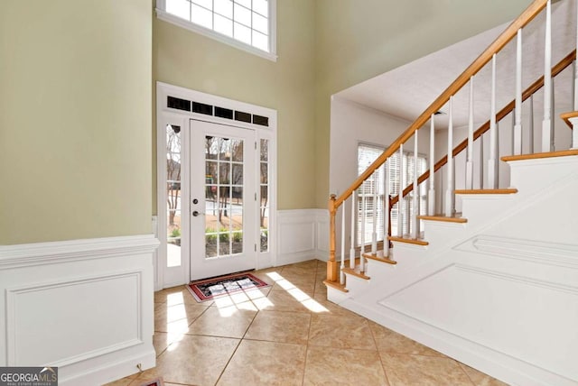 2002 Stonewick Ct, Lawrenceville, GA 30043 - tiled foyer featuring a decorative wall, a towering ceiling, stairs, and a wainscoted wall