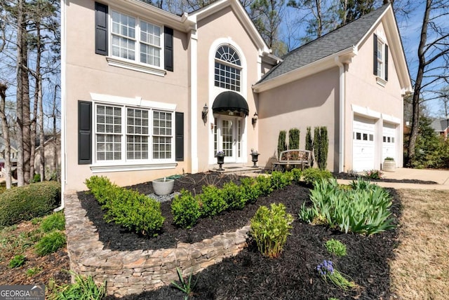 2002 Stonewick Ct, Lawrenceville, GA 30043 - view of front of home featuring stucco siding, driveway, roof with shingles, and a garage