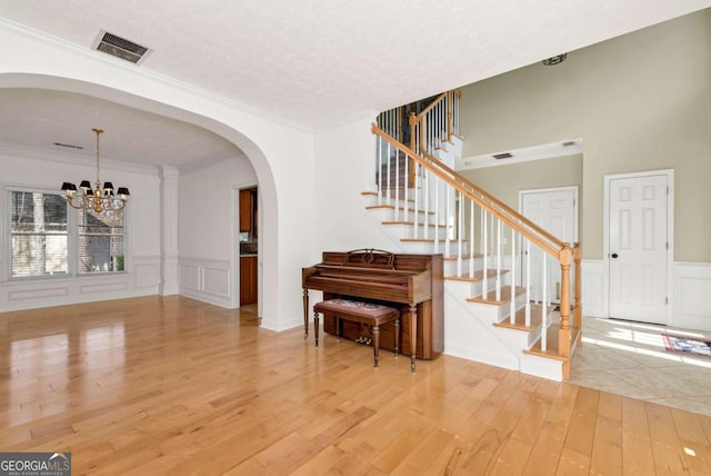 2002 Stonewick Ct, Lawrenceville, GA 30043 - entrance foyer with light wood-type flooring, arched walkways, stairs, crown molding, and a chandelier