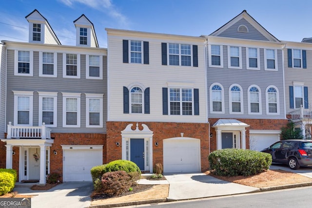 townhome / multi-family property with an attached garage, brick siding, and driveway
