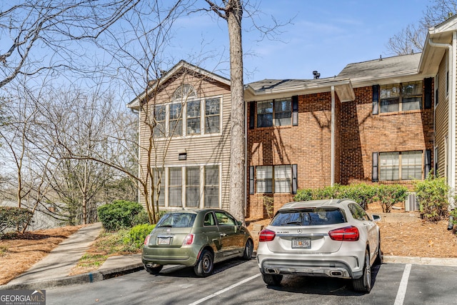 multi unit property with brick siding and uncovered parking