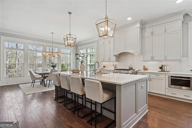 kitchen with a chandelier, stainless steel appliances, light countertops, recessed lighting, and dark wood-type flooring