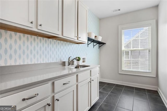 bathroom with toilet, vanity, baseboards, and bath / shower combo with glass door