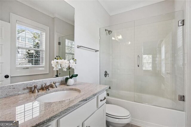 full bath with toilet, a shower stall, vanity, and ornamental molding