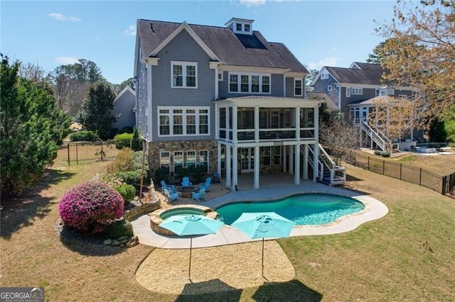 back of property with stairs, a pool with connected hot tub, a patio area, a sunroom, and stone siding