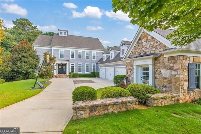 view of front of house featuring stone siding, a garage, concrete driveway, and a front lawn