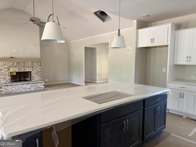 kitchen featuring white cabinets, a ceiling fan, open floor plan, a kitchen island, and vaulted ceiling