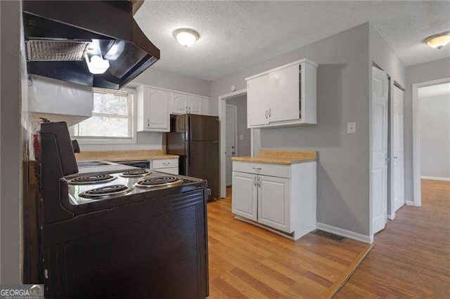 2522 Brentwood Ct, Decatur, GA 30032 - kitchen with black appliances, light wood-style flooring, a textured ceiling, white cabinetry, and ventilation hood