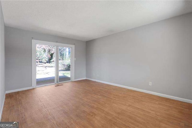 2522 Brentwood Ct, Decatur, GA 30032 - spare room with wood finished floors, baseboards, and a textured ceiling