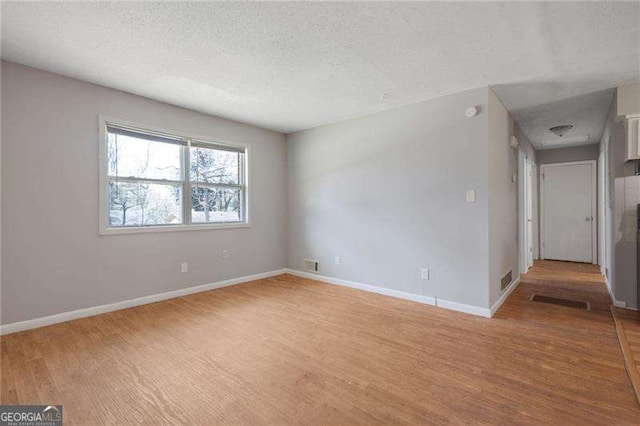 2522 Brentwood Ct, Decatur, GA 30032 - empty room featuring visible vents, baseboards, light wood finished floors, and a textured ceiling