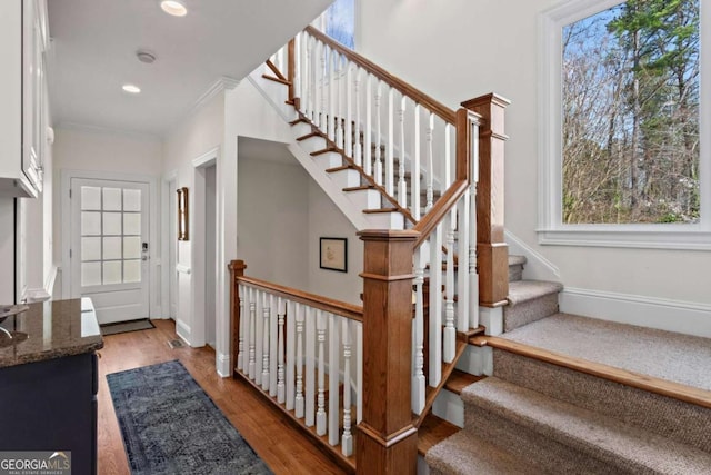 entryway with wood finished floors, baseboards, recessed lighting, stairs, and crown molding