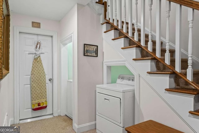 interior space with light carpet, washer / clothes dryer, and baseboards