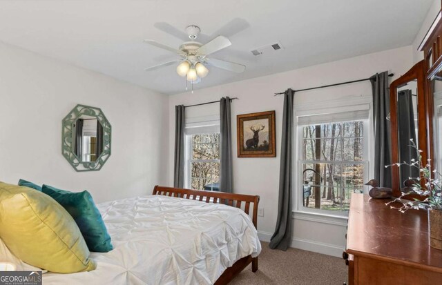 carpeted bedroom with baseboards, visible vents, and ceiling fan