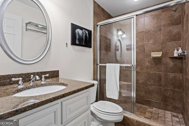 bathroom with vanity, toilet, and a shower stall