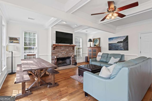 living room featuring beam ceiling, crown molding, light wood finished floors, and ceiling fan