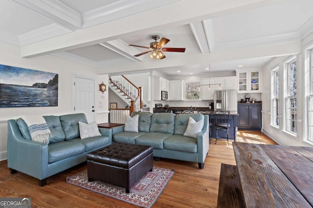 living area featuring ceiling fan, beamed ceiling, stairs, light wood-style floors, and coffered ceiling