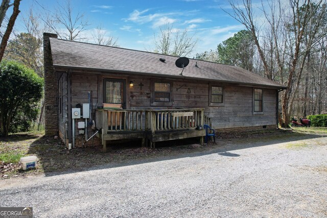 view of front facade with crawl space and a shingled roof