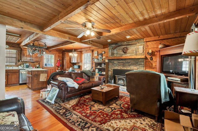 living room featuring beamed ceiling, ceiling fan with notable chandelier, light wood-style floors, wood walls, and wood ceiling