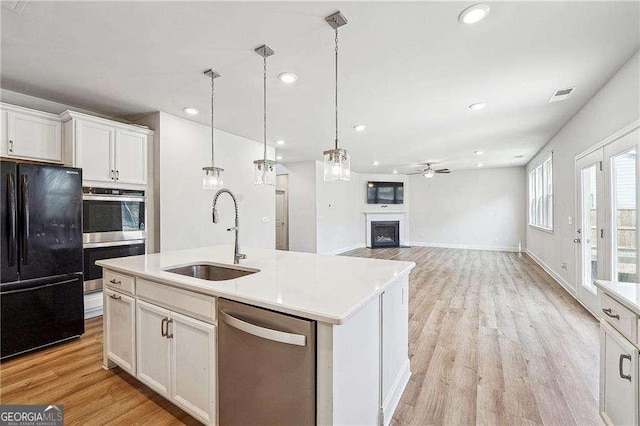 kitchen with visible vents, ceiling fan, light wood-style flooring, stainless steel appliances, and a sink