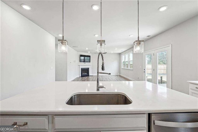 kitchen featuring a sink, open floor plan, light countertops, recessed lighting, and stainless steel dishwasher