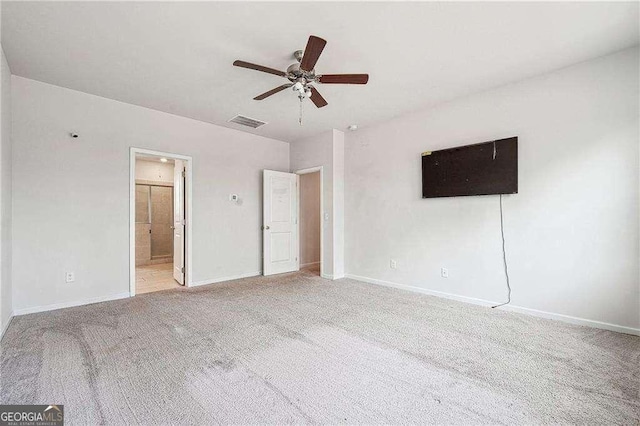 unfurnished bedroom featuring visible vents, baseboards, ceiling fan, ensuite bathroom, and light colored carpet