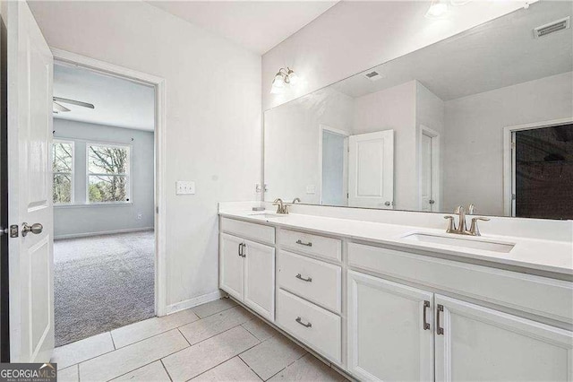 bathroom with a sink, visible vents, double vanity, and tile patterned flooring