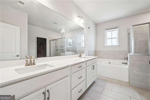 full bathroom featuring double vanity, a stall shower, a bath, and a sink