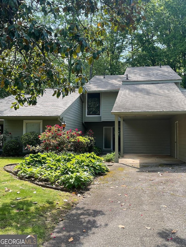 view of front facade featuring asphalt driveway and an attached carport