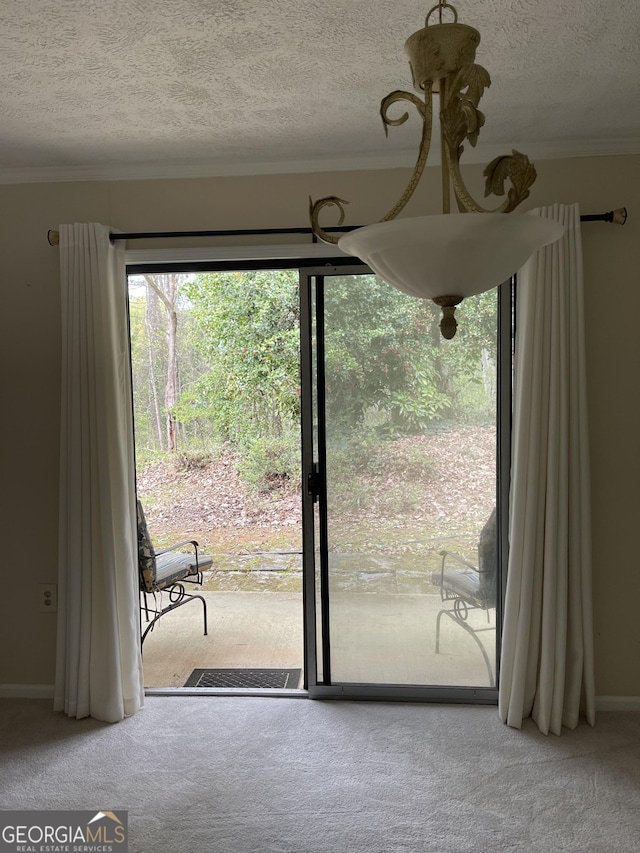 entryway featuring carpet floors, a textured ceiling, ornamental molding, and baseboards