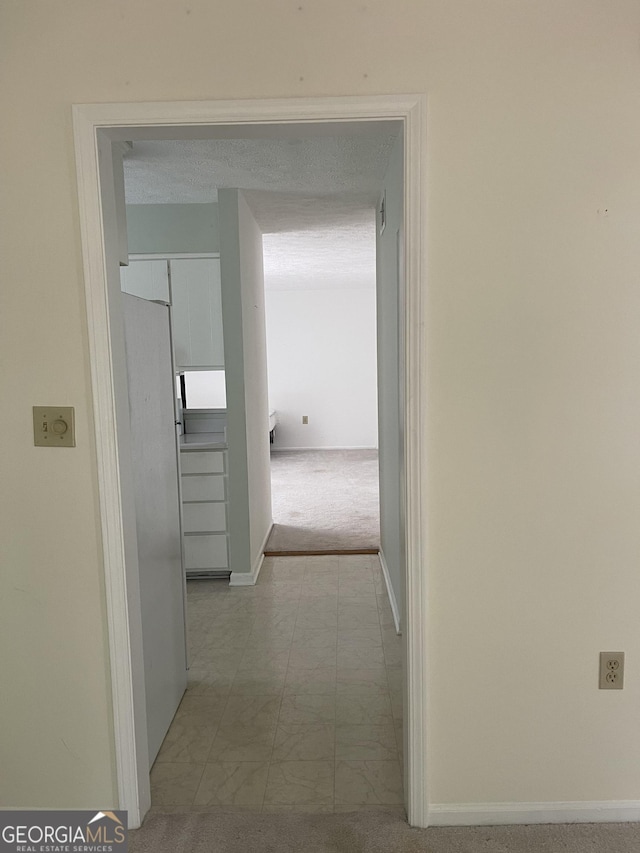 corridor featuring carpet floors and baseboards