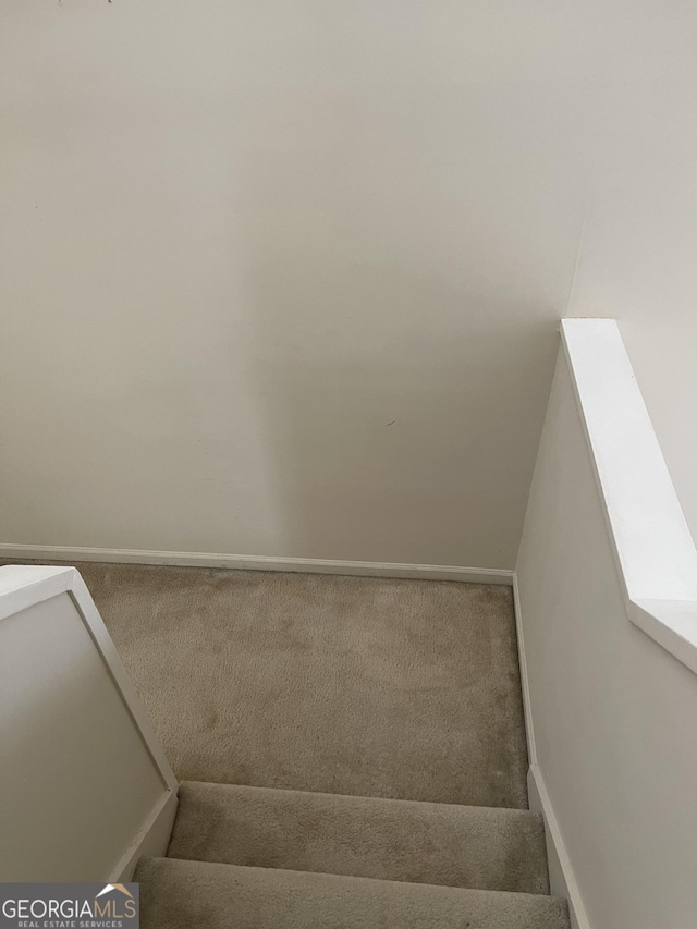 stairway featuring carpet and baseboards