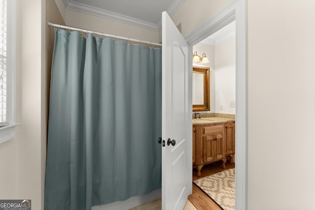 full bath featuring curtained shower, vanity, wood finished floors, and crown molding
