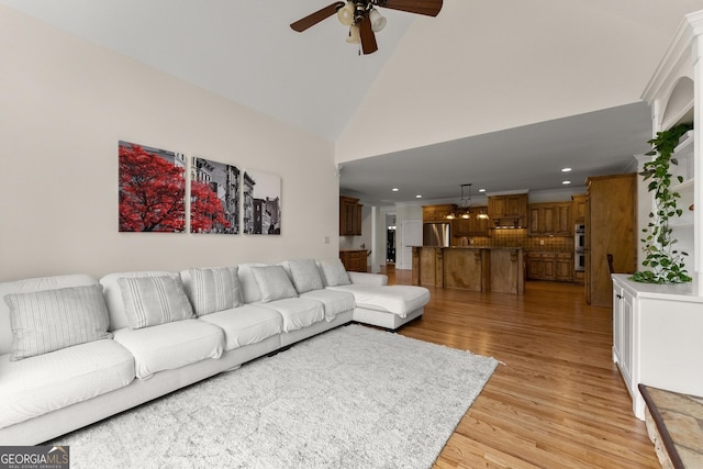 living room with recessed lighting, high vaulted ceiling, light wood-style floors, and ceiling fan