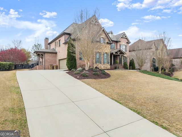 view of front of home featuring a garage, a front yard, brick siding, and driveway
