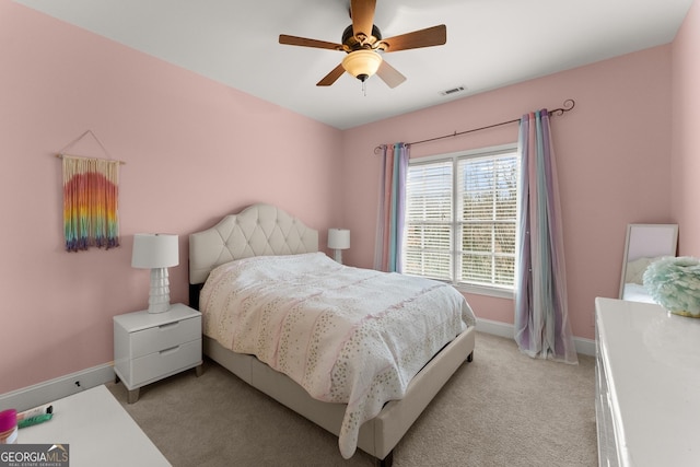 bedroom featuring a ceiling fan, baseboards, visible vents, and light carpet