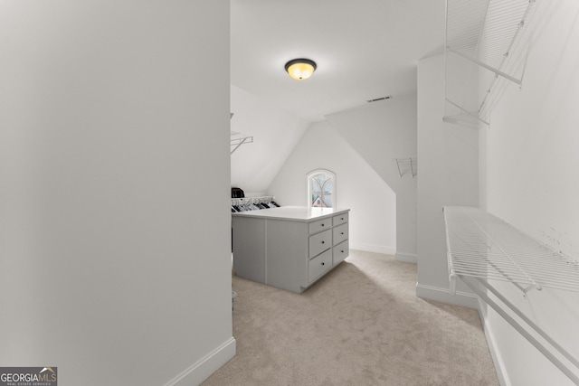 spacious closet with visible vents, light carpet, and lofted ceiling