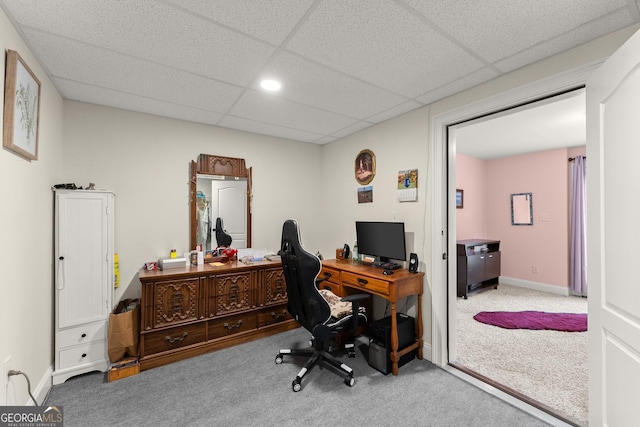 carpeted home office with a paneled ceiling and baseboards