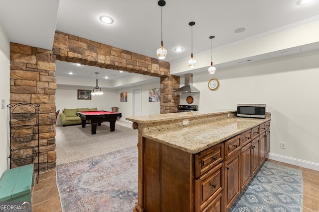 kitchen with billiards, light stone countertops, stainless steel microwave, wall chimney exhaust hood, and open floor plan