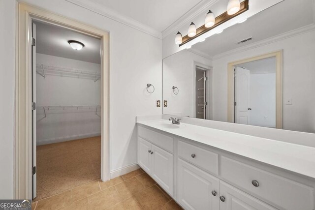 1372 Buckingham Ct, Watkinsville, GA 30677 - bathroom featuring vanity, a walk in closet, crown molding, and visible vents