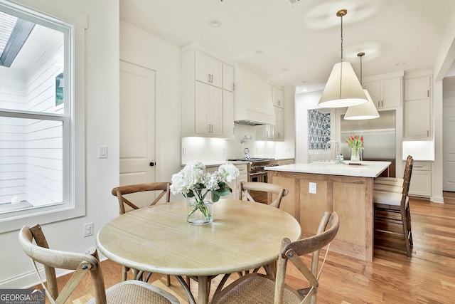 dining space featuring baseboards, light wood-type flooring, and recessed lighting