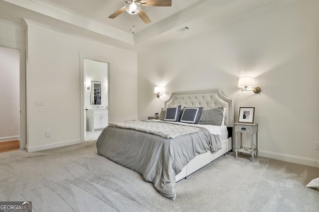 bedroom featuring light colored carpet, baseboards, a raised ceiling, connected bathroom, and visible vents