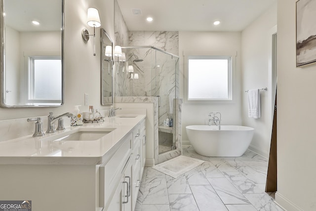 bathroom featuring marble finish floor, a freestanding bath, a sink, and a marble finish shower