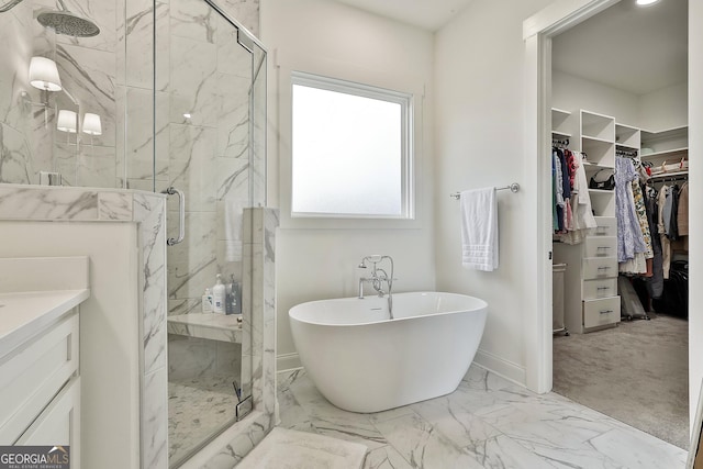 bathroom featuring marble finish floor, a freestanding tub, a spacious closet, and a marble finish shower