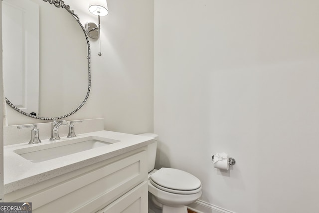 half bathroom with toilet and vanity