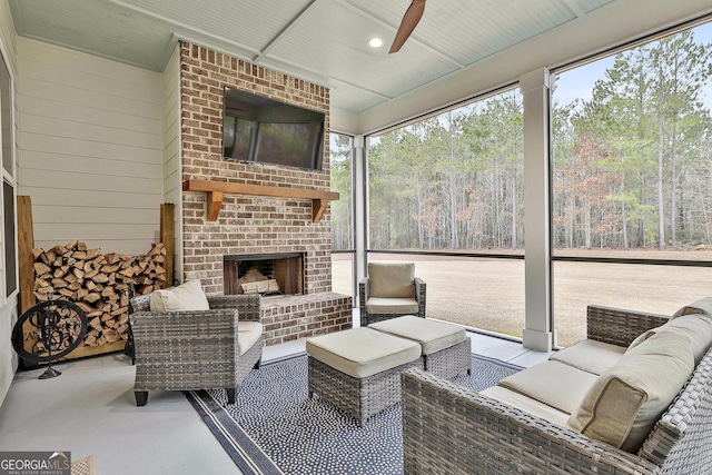 sunroom / solarium with an outdoor living space with a fireplace and a ceiling fan