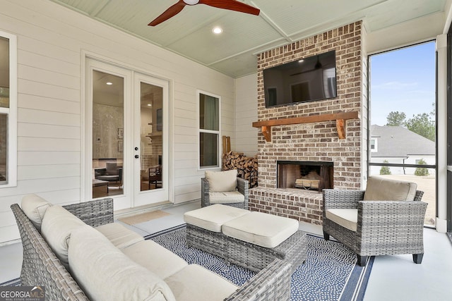 view of patio with an outdoor living space with a fireplace, ceiling fan, and french doors