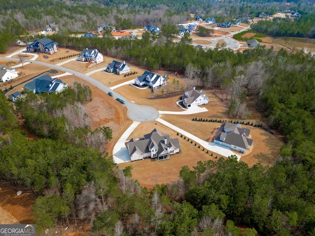 bird's eye view with a wooded view
