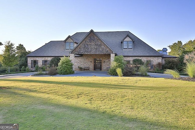 view of front of house with stone siding and a front lawn
