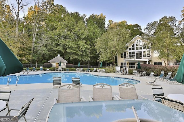 pool featuring fence and a patio