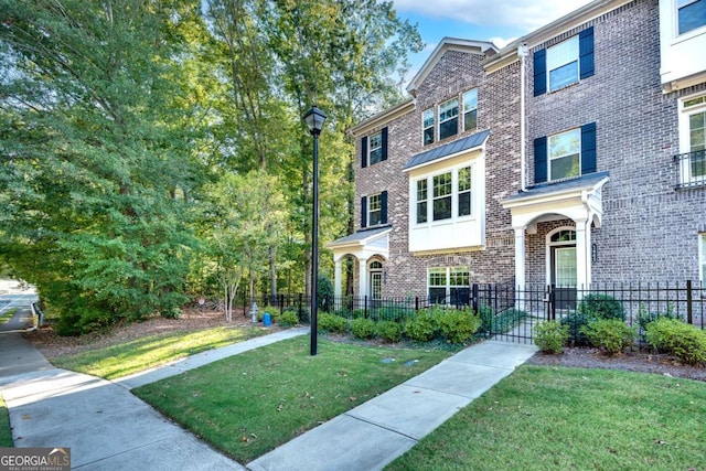 1007 Belle Ave, Roswell, GA 30076 - townhome / multi-family property featuring a fenced front yard, brick siding, and a front lawn